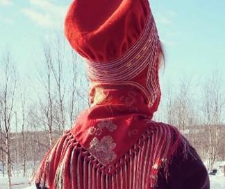 En koftekledd liten jente som ser utover blå himmel. - Deaddil ja stuora govva ihtá